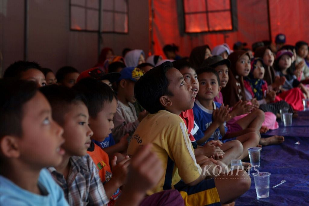 Anak-anak korban longsor dan anak-anak warga di sekitar lokasi longsor diajak bermain dan belajar oleh sukarelawan di tenda posko bencana di Dusun Cimapag, Desa Sirnaresmi, Kecamatan Cisolok, Kabupaten Sukabumi, terus dilanjutkan, Sabtu (5/1/2019).