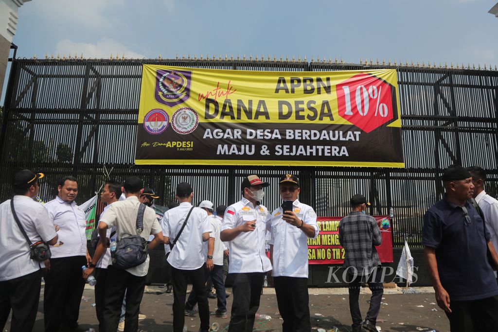 Peserta aksi yang terdiri atas perangkat desa berkumpul di depan Gedung DPR, Jakarta, Rabu (5/7/2023), setelah aksi selesai. 