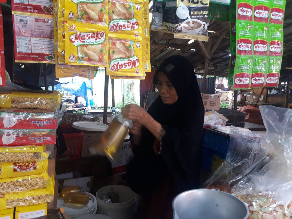 Yulimar (65) memasukkan minyak ke dalam plastik di Pasar Petamburan, Jakarta Pusat, DKI Jakarta, Kamis (3/11/2022).