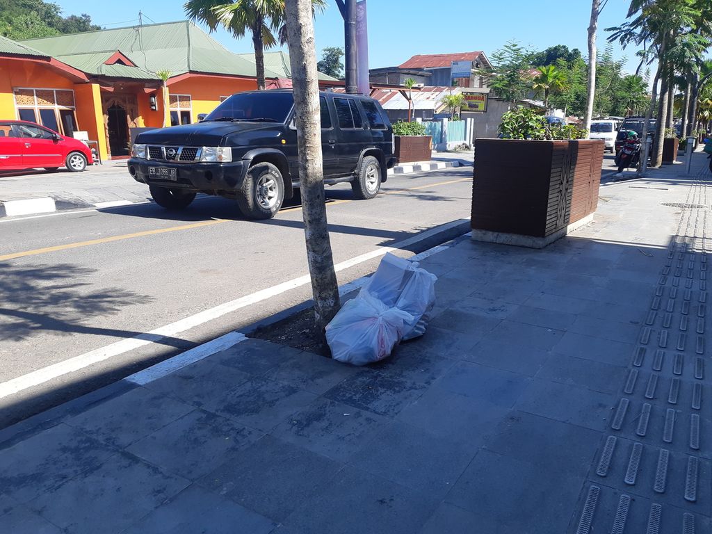 Warga membuang sampah di atas trotoar sisi Jalan Soekarno-Hatta, pusat kota Labuan Bajo, Kabupaten Manggarai Barat, Nusa Tenggara Timur, pada Kamis (4/5/2023). Lima hari lagi hajatan KTT ASEAN akan digelar di kota itu. 