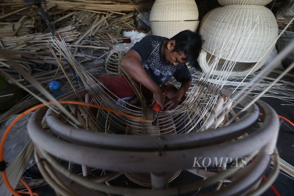 Pekerja menggarap kerajinan mebel berbahan rotan di Desa Luwang, Gatak, Sukoharjo, Jawa Tengah, Senin (11/4/2022). Industri kerajinan rotan saat ini masih menjadi sumber mata pencarian bagi ratusan penduduk di kawasan Transan. Bahan baku untuk kerajinan tersebut didatangkan dari Kalimantan.