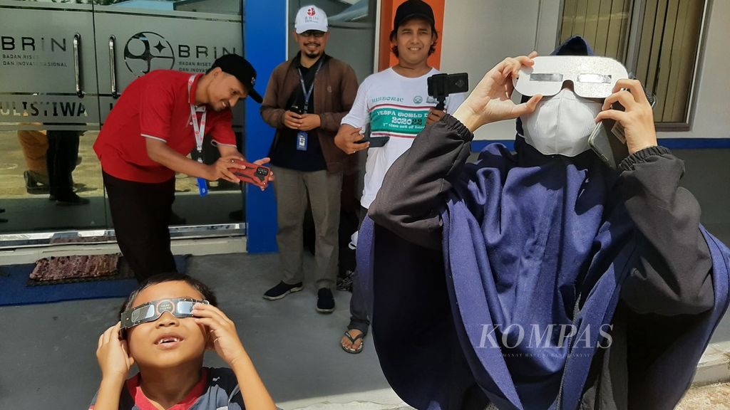 Warga mengamati gerhana matahari sebagian dengan kacamata khusus di Halaman Kantor Badan Riset dan Inovasi Nasional (BRIN) Kawasan Pontianak, Kalimantan Barat, Kamis (20/4/2023).