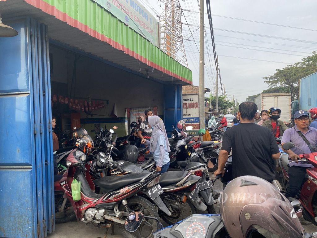 Pekerja di kawasan Lamicitra Pelabuhan Tanjung Emas mengantre memperbaiki sepeda motornya di sebuah bengkel di Jalan Pantura, Kecamatan Semarang Utara, Senin (23/5/2022). 