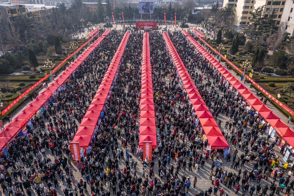 Foto dari udara yang diambil pada 25 Februari 2024 ini memperlihatkan kumpulan warga yang menghadiri pameran lapangan kerja di Zhengzhou, Provinsi Henan, China tengah. 