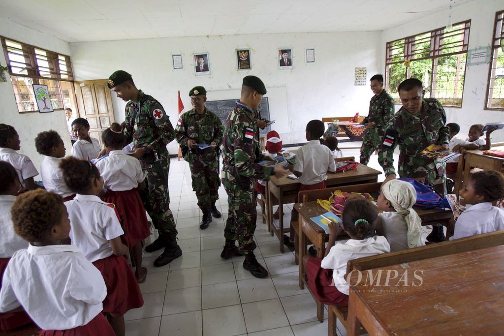 Satgas Pamtas RI-PNG dari Yonif Para Raider 432/Kostrad memberikan buku tulis untuk menyemangati siswa di SDN Mosso, Distrik Muara Tami, Jayapura, Papua, Senin (17/7). 