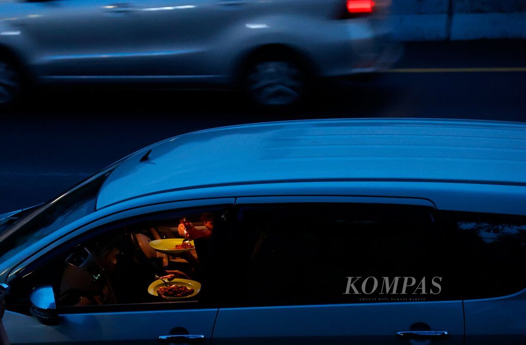 Pengendara mobil menyempatkan berbuka puasa saat berhenti di luar area tempat istirahat Kilometer 429, Ungaran, Kabupaten Semarang, Jawa Tengah, April 2023.