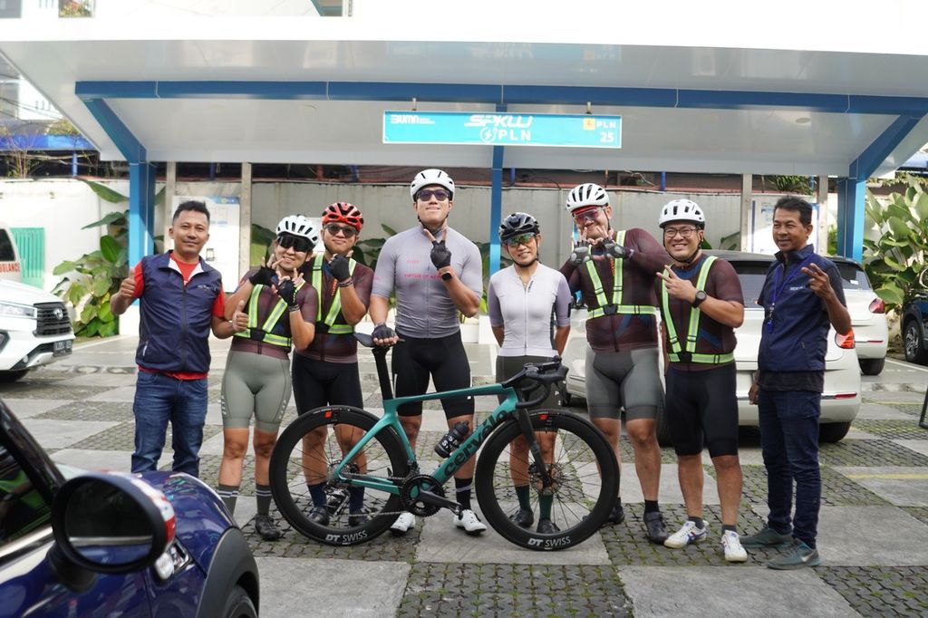 Para pesepeda yang mengikuti Check Out Ride-Road to Cycling De Jabar 2024 berfoto bersama di depan salah satu stasiun pengisian kendaraan listrik umum atau SPKLU di Braga, Kota Bandung, Jawa Barat, Minggu (5/5/2024). 