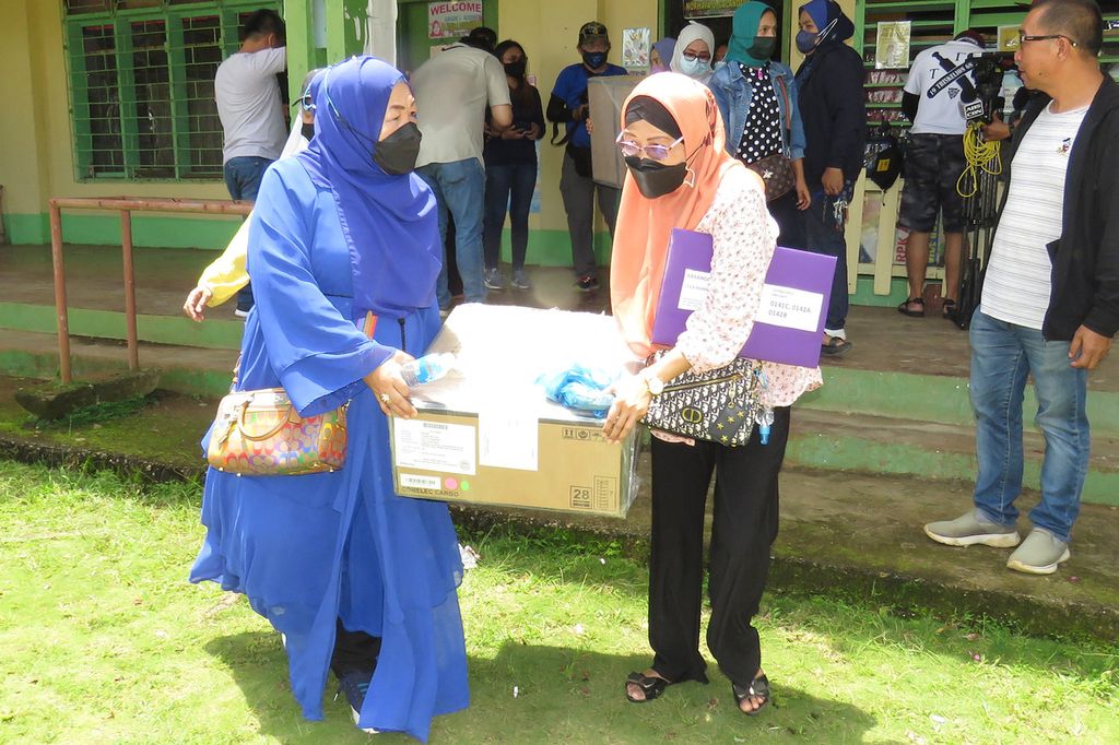 Panitia pemilihan membawa mesin penghitung suara dan alat lainnya di sebuah lokasi di Kota Marawi, Filipina, Kamis (5/5/2022). 