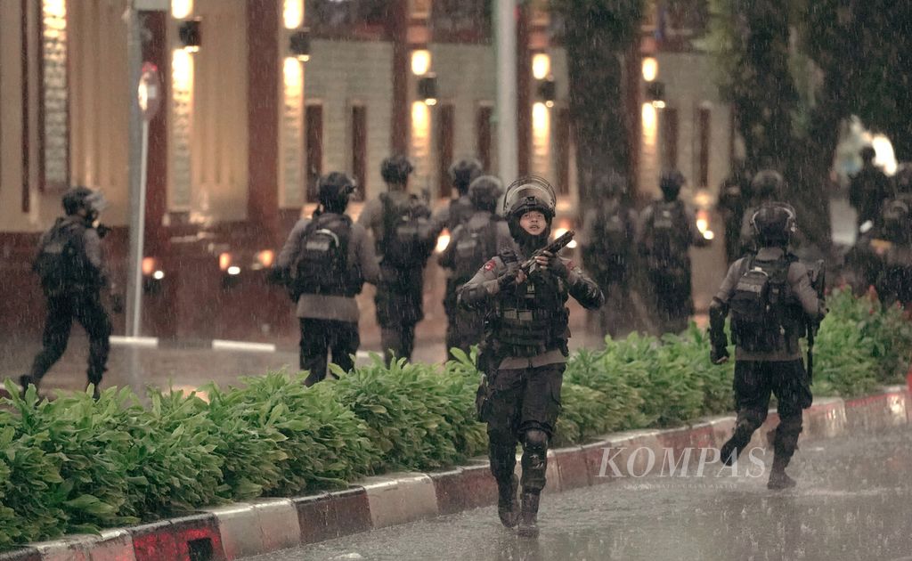 Polisi berlarian dengan senjata laras panjang mengamankan Mabes Polri di Jakarta Selatan, Rabu (31/3/2021). Mabes Polri memperketat penjagaan pascaserangan dari terduga teroris yang tewas seusai baku tembak. 