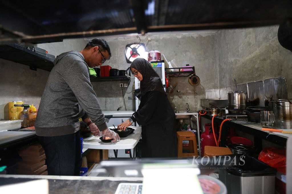 Pasangan suami istri Twino Widya Iskandar dan Gemy Swari Armyn bersama-sama mempersiapkan bahan untuk kedai ramen yang mereka kelola di kawasan Limo, Depok, Jawa Barat, Sabtu (17/9/2022). 
