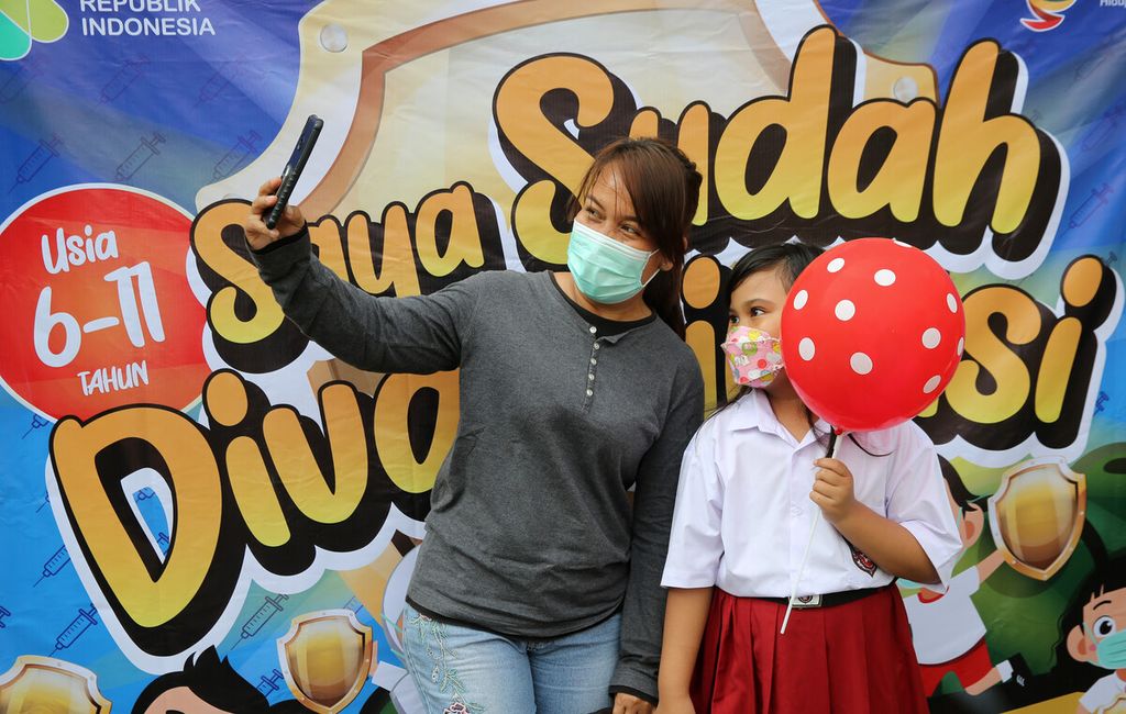 Orangtua murid dan putrinya berswafoto setelah menerima suntikan vaksin Sinovac di SDN 02 Pondok Bambu, Jakarta Timur, Selasa (14/12/2021). 