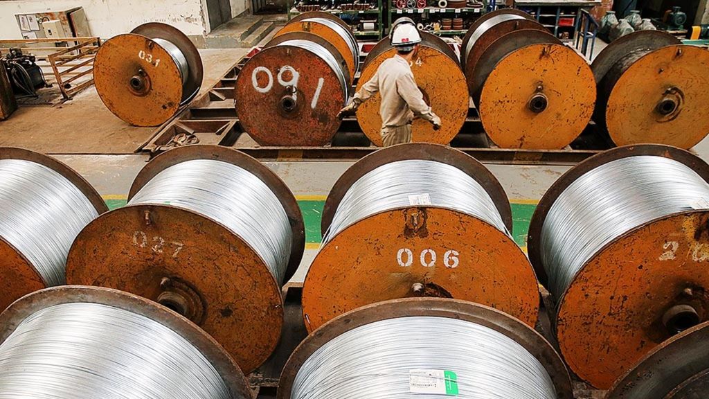 Seorang pekerja berjalan melewati gulungan kawat baja di sebuah pabrik di Nantong, Provinsi Jiangsu, China, Selasa (3/7/2018). Ketegangan perdagangan antara China dan AS mengarah pada situasi perang dagang yang memengaruhi banyak negara.