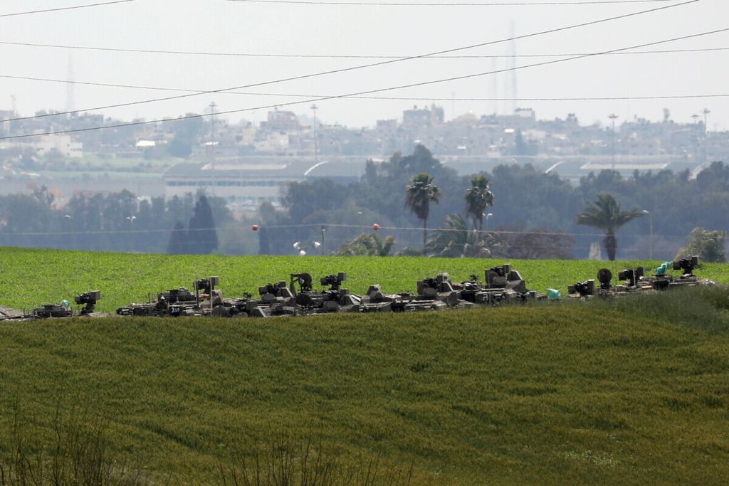  Iring-iringan kendaraan lapis baja militer Israel terlihat di sebuah ladang dengan latar belakang langit di angkasa Gaza di wilayah selatan Israel, 26 Maret 2019. 
