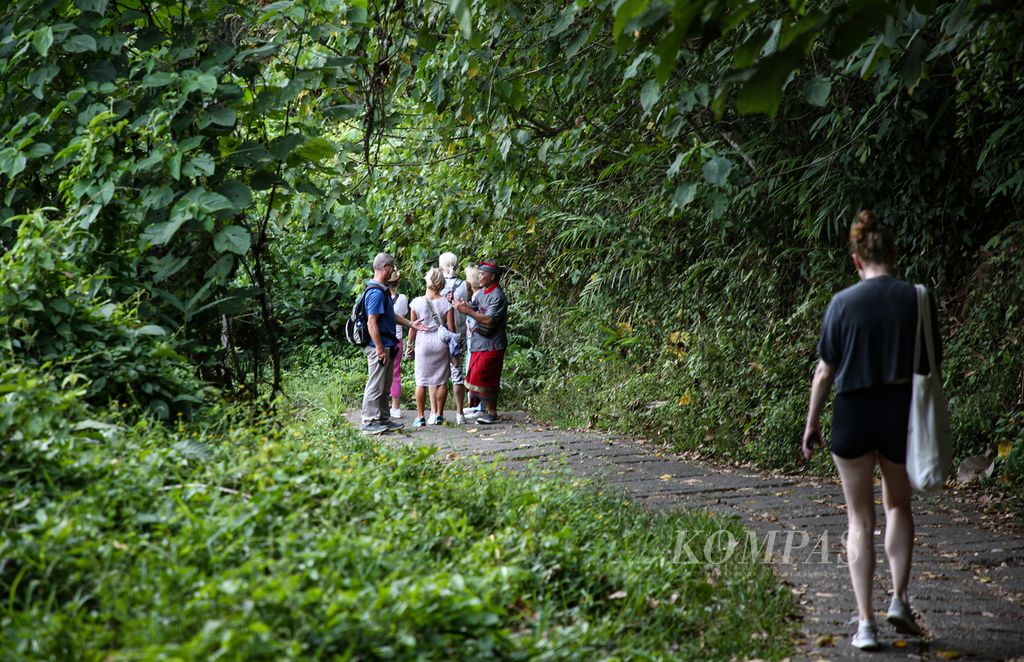 Pemandu wisata membawa rombongan wisatawan mancanegara menyusuri jalur <i>trekking</i> Bukit Campuhan di Ubud, Kabupaten Gianyar, Bali, Jumat (22/9/2023). 