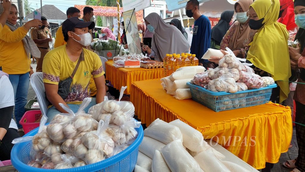 Warga antre membeli bahan kebutuhan pokok di lokasi Pasar Murah Ramadhan 1443 Hijriah, Senin (4/4/2022). Pasar murah tersebut digelar di halaman Kantor Dinas Perdagangan Provinsi Kalimantan Selatan di Banjarmasin.