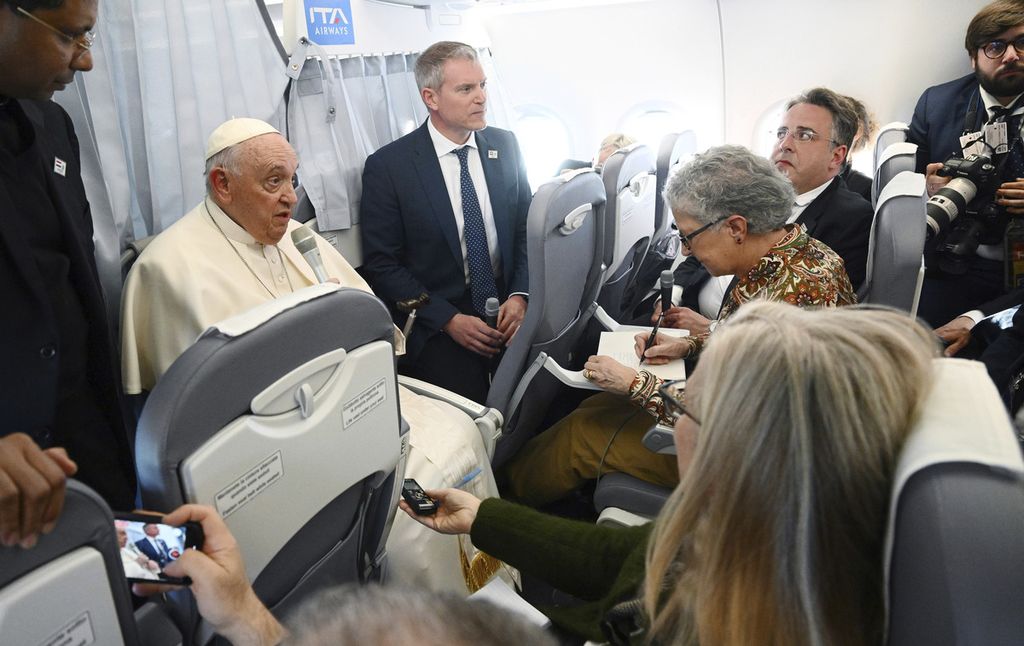 Paus Fransiskus menggelar sesi tanya jawab dengan wartawan dalam pesawat saat perjalanan pulang dari Budapest, Hongaria, menuju Roma, Minggu (30/4/2023). 