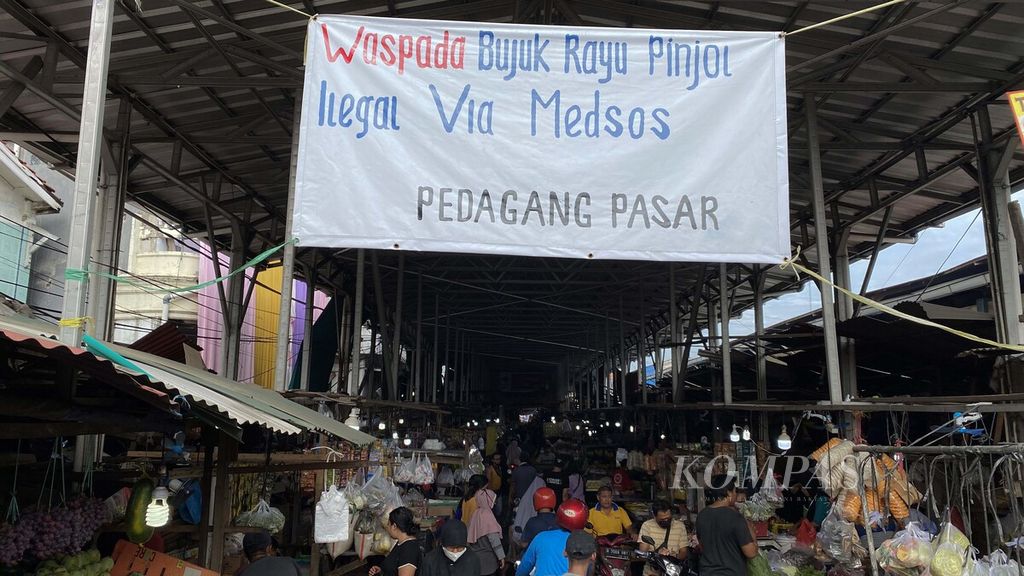 Spanduk ajakan untuk mewaspadai praktik pinjaman daring (pinjol) ilegal menghiasi pintu masuk Pasar Muara Angke, Penjaringan, Jakarta Utara, Minggu (14/11/2021). 