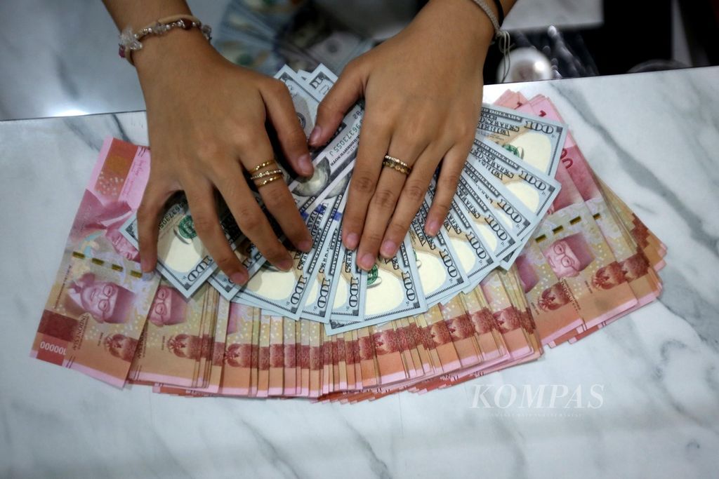 Pegawai memeriksa uang dollar AS di tempat penukaran valuta asing Dolarindo di kawasan Blok M, Jakarta Selatan, Jumat (21/6/2024).