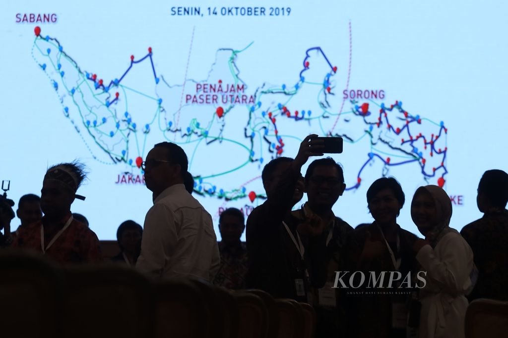 Tamu undangan berfoto dengan latar peta proyek Palapa Ring seusai peresmian pengoperasiannya oleh Presiden Joko Widodo di Istana Negara, Jakarta, Senin (14/10/2019). 