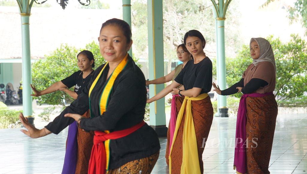Para wisatawan menari dengan para abdi dalem dalam kelas menari, di Pura Mangkunegaran, Kota Surakarta, Jawa Tengah, Kamis (29/12/2022). Itu merupakan atraksi budaya tambahan yang disuguhkan pengelola pura bagi wisatawan semasa libur akhir tahun 2022.