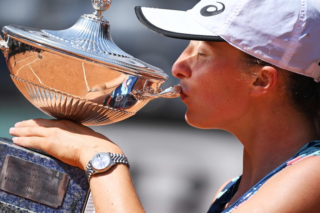 Petenis Polandia, Iga Swiatek, mencium trofi juara turnamen WTA 1000 Roma setelah mengalahkan petenis Tunisia, Ons Jabeur, pada pertandingan final di Foro Italico, Roma, Italia, Minggu (15/5/2022). Swiatek menjadi unggulan teratas Perancis Terbuka, pada 22 Mei-5 Juni 2022. 