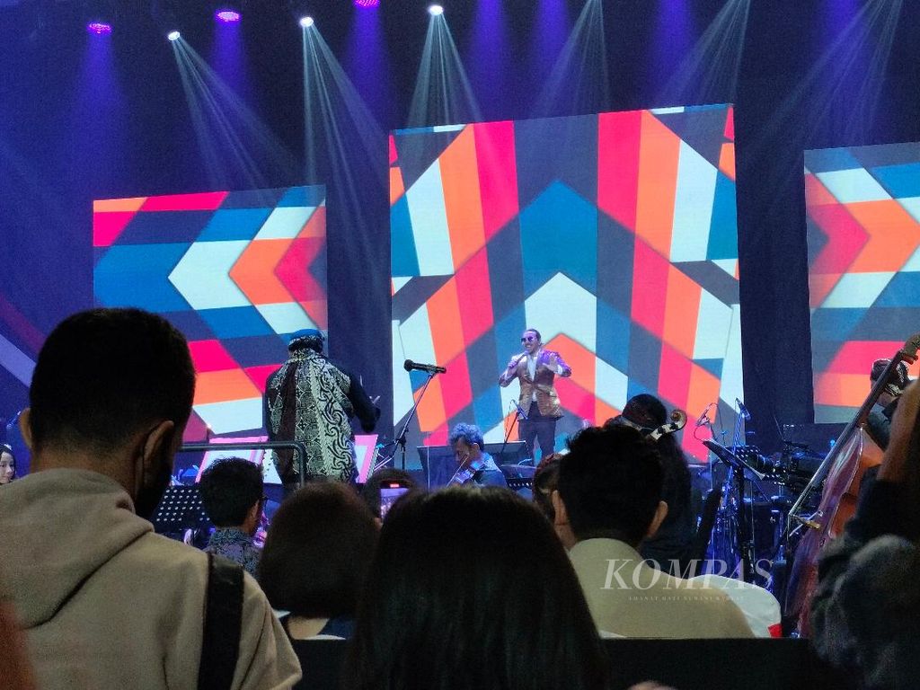 Artis penyanyi David Bayu Danangjaya bernyanyi dengan latar belakang warna warni dalam acara Rhapsody Nusantara yang digelar di Diamond Solo Convention Center, Jumat (28/10/2022).