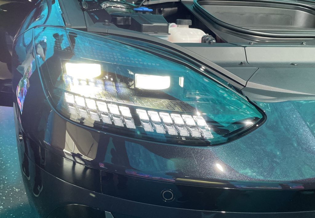 Lampu depan Hyundai Ioniq 6 terdiri atas dua LED utama yang pendaran dan arah sorotnya bisa beradaptasi dengan cahaya dari arah berlawanan. Bagian bawah LED utama itu adalah dua baris lampu yang berfungsi sebagai lampu sein dan lampu siang.