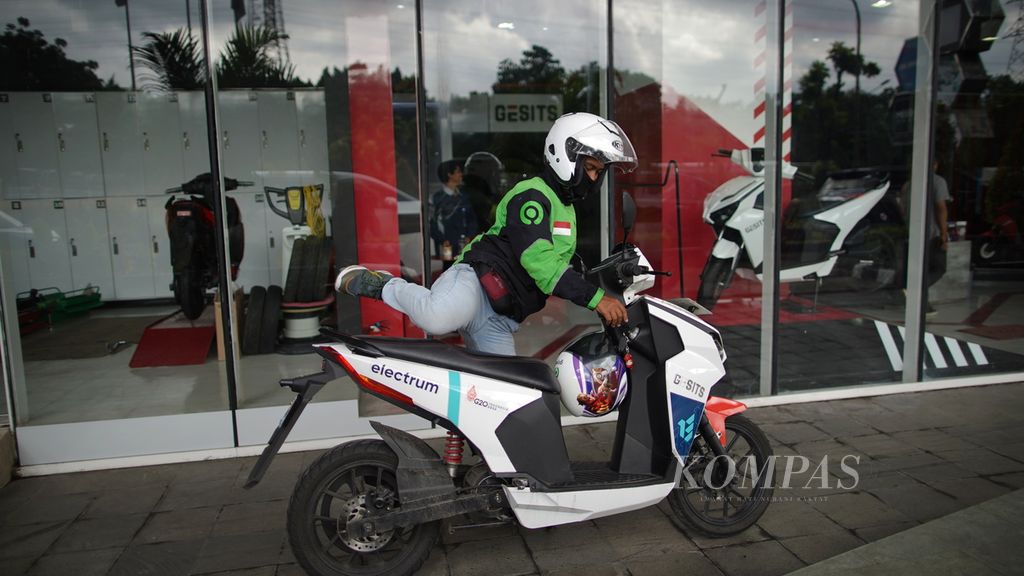 Ojek daring bersiap mengendarai motor listrik Gesits G1 setelah di servis di kawasan The Hive, Jakarta Timur, Kamis (9/3/2023).   
