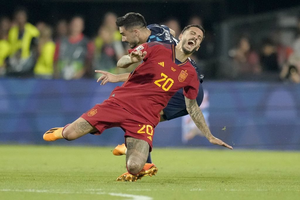 Pemain Spanyol Joselu (depan) dan pemain Kroasia Lovro Majer terjatuh saat berebut bola pada laga final Liga Nasional Eropa di Stadion Feyeenord, Rotterdam, Senin (19/6/2023) dini hari WIB. Spanyol menjadi juara setelah menang 5-4 pada adu penalti.