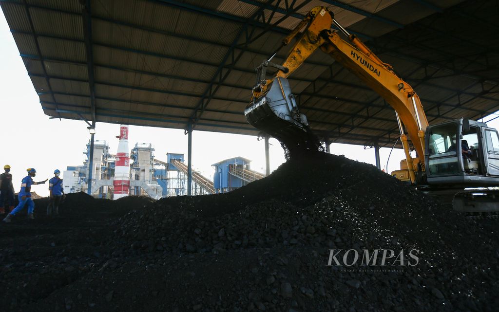 Eskavator mencampur sampah biomassa berupa cangkang kemiri dengan batubara di Pembangkit Listrik Tenaga Uap (PLTU) Ropa di Desa Keliwumbu, Kecamatan Mourole, Kabupaten Ende, Nusa Tenggara Timur, Kamis (7/10/2021). PLTU Ropa dengan kapasitas 2x7 megawatt (MW) ini melakukan metode <i>co-firing </i>dengan memanfaatkan sampah biomassa sebesar 5 persen sebagai substitusi atau campuran batubara.