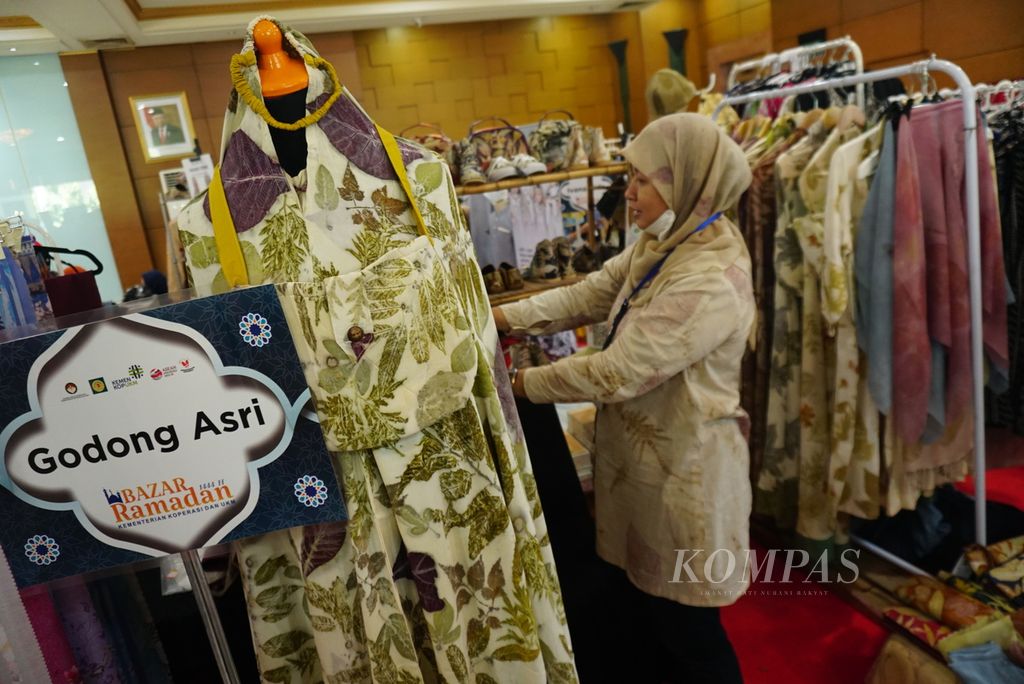 Asriningtyas (43) menata baju-baju dagangannya ketika mengikuti Bazaar UMKM yang digelar di halaman kantor Kementerian Koperasi dan Usaha Kecil Menengah di Jakarta, Rabu (12/4/2023).