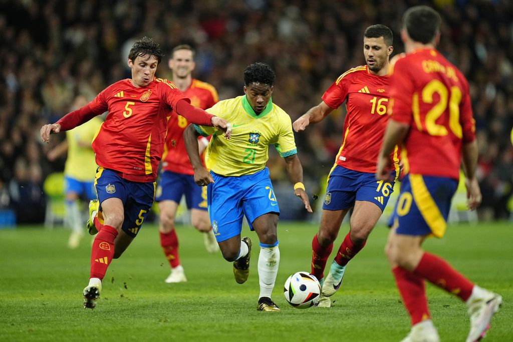 Aksi penyerang Brasil, Endrick, coba meloloskan diri dari kepungan pemain Spanyol dalam pertandingan persahabatan antara Spanyol dan Brasil di Stadion Santiago Bernabeu, Madrid, Spanyol, Rabu (27/3/2024) dini hari WIB. 