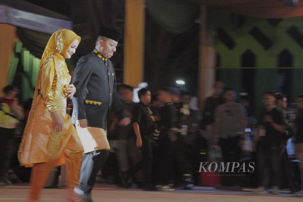 Penjabat Gubernur Aceh Achmad Marzuki dan istrinya, Ayu Candra Febiola Nazuar, menuju panggung utama saat pembukaan Pekan Kebudayaan Aceh (PKA) Ke-8 di Taman Sulthanah Safiatuddin, Kota Banda Aceh, Aceh, Sabtu (4/11/2023). PKA berlangsung pada 4-12 November 2023.