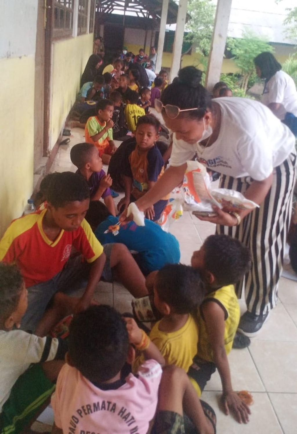 Tim Ikatan Guru Indonesia Flores Timur menyambangi anak-anak pengungsi di lokasi pengungsian di desa Pululera, 5 km sebelah utara gunung Lewotobi Laki-laki, Selasa (9/1/2024). Selain membagikan makanan ringan, juga mengajak anak-anak pengungsi yang kebanyakan sedang di bangku pendidikan, bernyanyi bersama.
