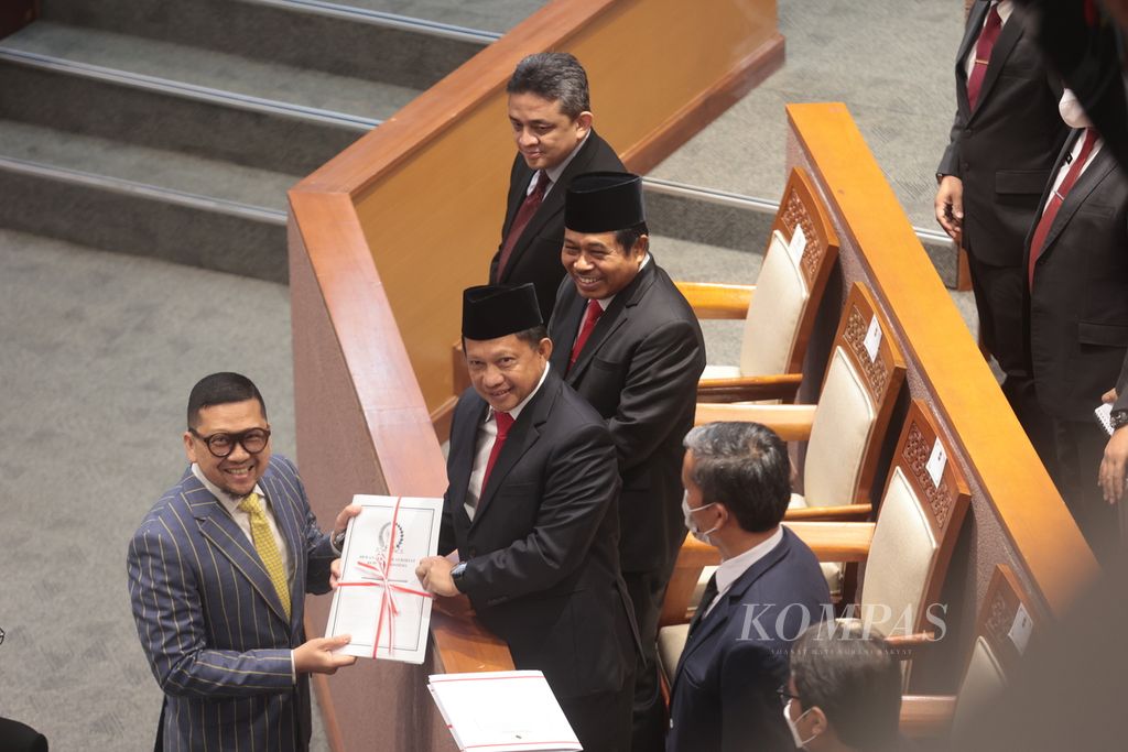 Menteri Dalam Negeri Tito Karnavian (kanan) menerima salinan rancangan undang-undang, salah satunya salinan RUU Perppu Pemilu, dari Ketua Komisi II DPR Ahmad Doli Kurnia saat Rapat Paripurna DPR di Kompleks Parlemen, Senayan, Jakarta, Selasa (4/4/2023). 