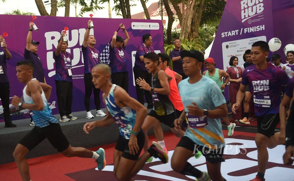 Menteri Perhubungan Budi Karya Sumadi mengibarkan bendera start kategori 10 km pada RUNHUB di Balai Kota Surabaya, Minggu (8/10/2023). Lomba lari RUNHUB diikuti oleh 2.000 pelari. RUNHUB diselenggarakan oleh Kementerian Perhubungan bekerja sama dengan harian <i>Kompas</i> dan didukung BOOK Cabin yang merupakan bagian Lion Group. 