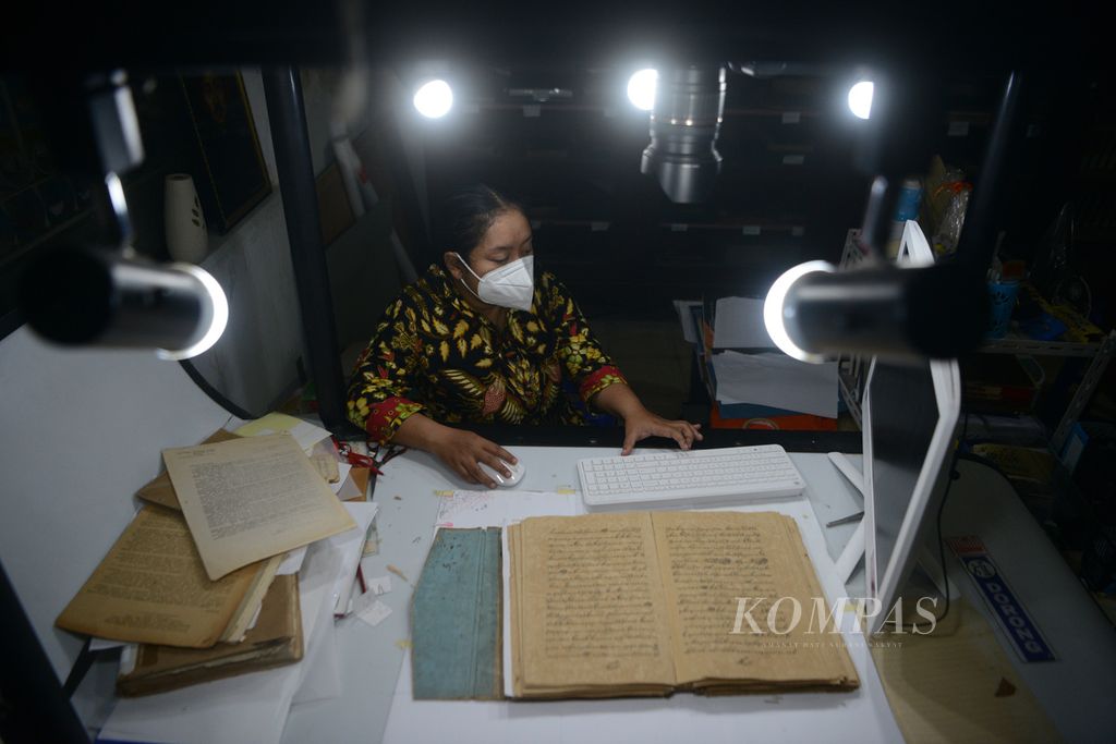 Petugas pengelola manuskrip, Kurnia Heniwati, memeriksa proses digitalisasi naskah kuno <i>Suluk Syattariyah</i> di Museum Radya Pustaka, Surakarta, Jawa Tengah, Rabu (17/3/2021). Digitalisasi dilakukan untuk menyelamatkan isi naskah kuno yang semakin rapuh karena usia. Museum yang didirikan pada tahun 1890 ini memiliki dokumen tertua berupa naskah <i>Serat Yusuf </i>yang dibuat tahun 1729.
