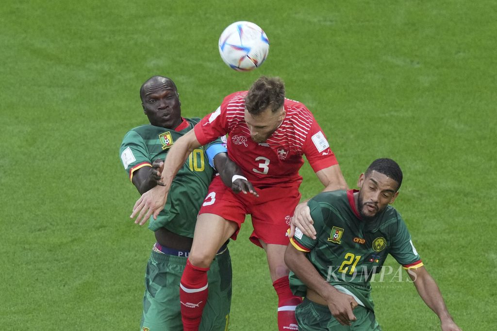 Pemain Swiss Silvan Widmer (tengah) berebut bola dengan para pemain Kamerun saat bertanding di babak fase Grup G Piala Dunia 2022 di Stadion Al Janoub, Qatar, Kamis (24/11/2022). Swiss menang 1-0 Kompas/Yuniadhi Agung (MYE) 24-11-2022