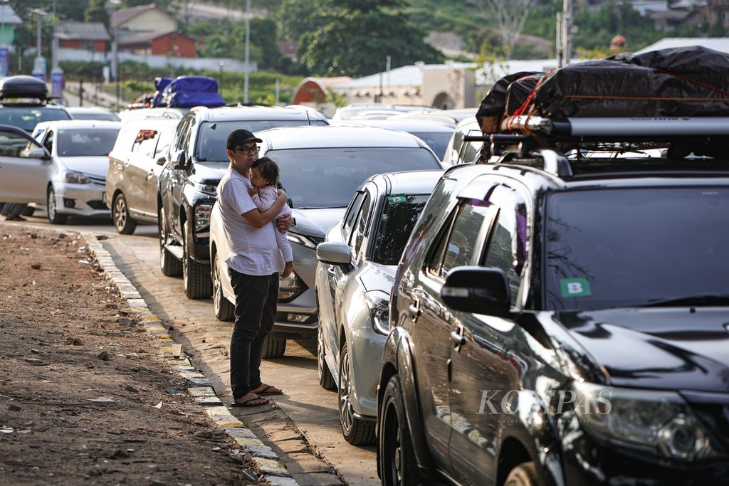 Prospective passengers carry their children while queuing to enter the ferry at Bakauheni Harbor, Lampung, Sunday (14/4/2024).
