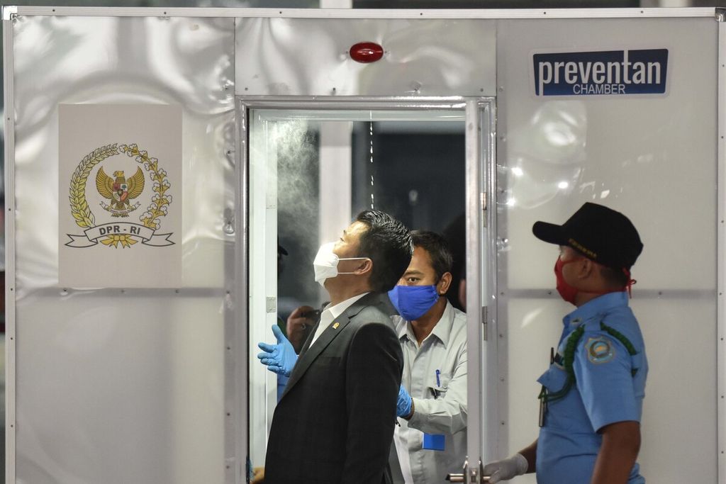 Anggota DPR memasuki bilik sterilisasi saat akan mengikuti Rapat Paripurna Pembukaan Masa Persidangan III di Gedung Nusantara, Kompleks Parlemen, Senayan, Jakarta, Senin (30/3/2020).