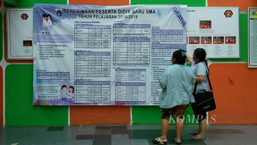 Orangtua calon peserta didik melihat pengumuman terkait pendaftaran peserta didik baru (PPDB) tahun ajaran 2018/2019 yang ditempel di dinding SMA Negeri 78 Jakarta, Kamis (21/6/2018). 