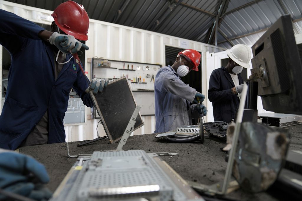 Karyawan WEEE Centre sedang membongkar limbah laptop di pabrik daur ulang, tempat pengumpulan di mana orang dapat membuang peralatan elektronik lama di Nairobi, Kenya, pada 20 Agustus 2024. 