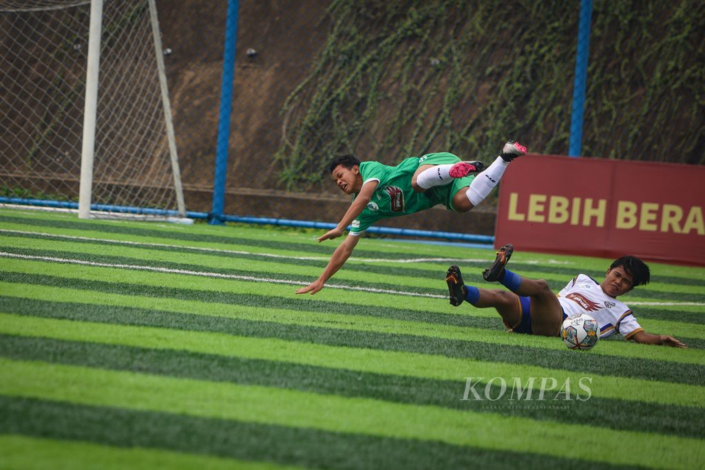 Pemain BMIFA, Ibrahim Movic Afriyansyah (kiri), terpental saat berebut bola dengan pemain Babek SS dalam laga babak utama Liga Kompas Kacang Garuda U-14 di Dewantara Sport Center, Tangerang Selatan, Banten, Minggu (3/12/2023). Babek SS mengalahkan BMIFA dengan skor 1-0. 2-2023 