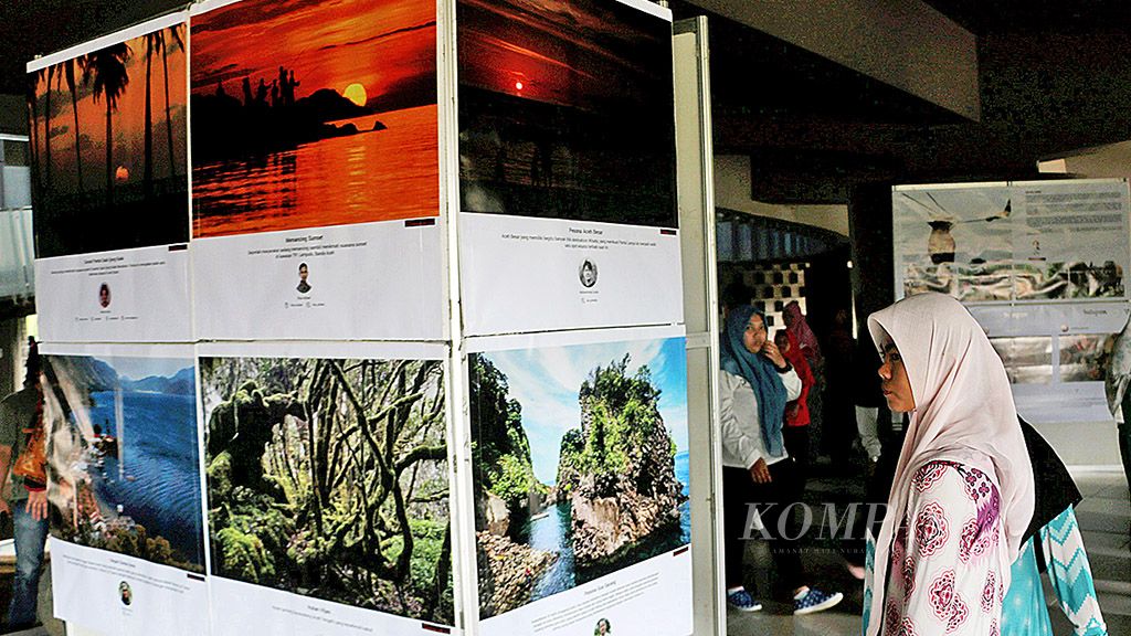 Pengunjung menyaksikan foto-foto pembangunan Aceh setelah 13 tahun bencana gempa dan tsunami yang dipamerkan di Museum Tsunami, Banda Aceh, Senin (25/12). Aceh mengalami kemajuan pesat, baik dari sektor ekonomi maupun infrastruktur, tetapi masih lemah pada bidang mitigasi bencana.