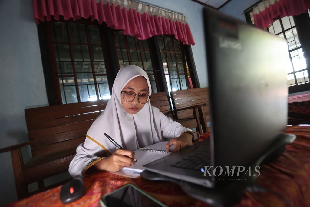 Rasid Ariyanti (21) mengikuti kuliah daring di rumahnya di Desa Wringinputih, Borobudur, Magelang, Jawa Tengah, Rabu (25/10/2023). Rasid adalah salah satu mahasiswi penerima beasiswa dari program Satu Rumah Satu Sarjana yang digalakkan di desa itu.