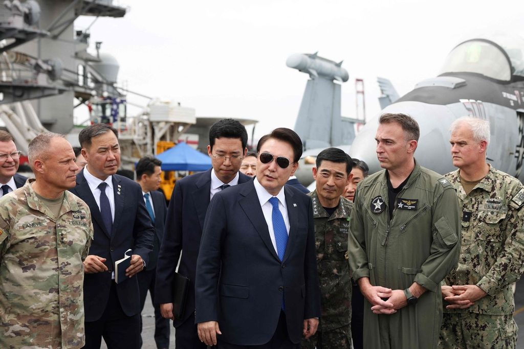 Presiden Korea Selatan Yoon Suk Yeol (tengah) berkunjung ke kapal induk AS, USS Theodore Roosevelt (CVN-71), di Pangkalan Angkatan Laut di Busan, Korsel, 25 Juni 2024. 