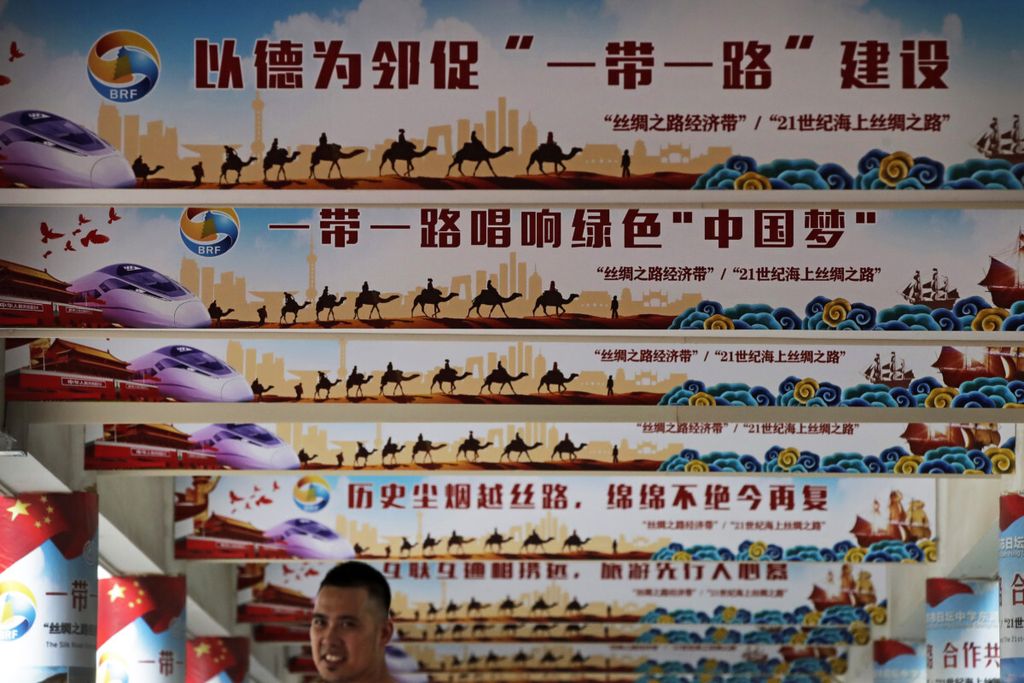 Seorang pria berdiri di bawah aneka spanduk yang berisi pesan Presiden China Xi Jinping tentang mimpi China dan program Sabuk dan Jalan. Foto diambil di Beijing, Jumat (29/6/2018). 