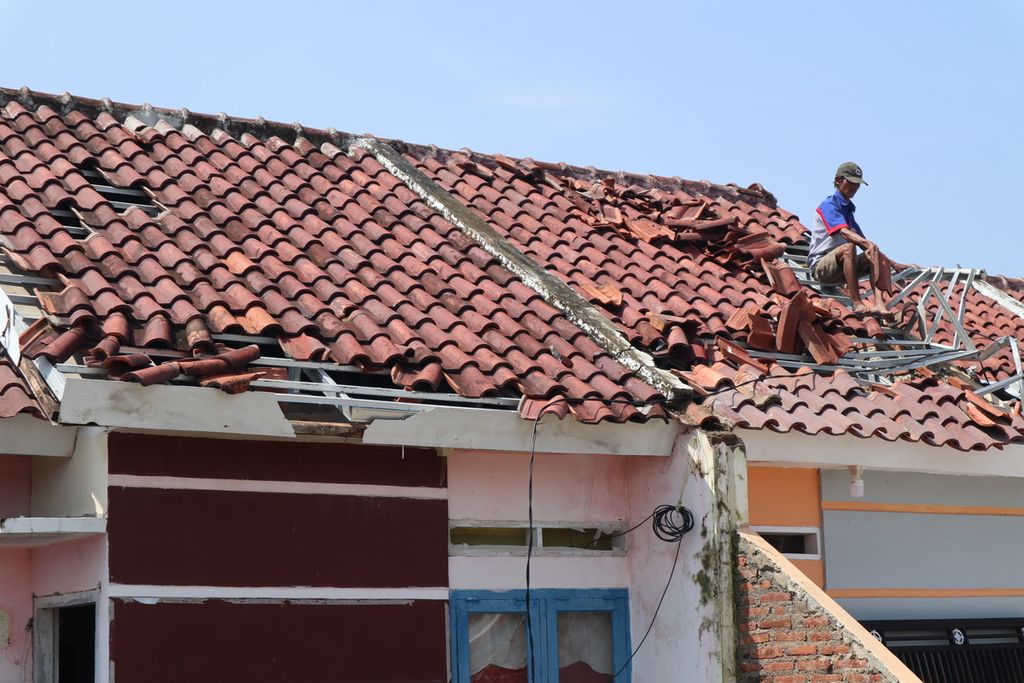 Residents install roof tiles that were previously damaged by a tornado in Kalimaro Village, Gebang District, Cirebon Regency, West Java, Tuesday (12/28/2021). The disaster that occurred on Monday (12/27/2021) that afternoon damaged at least 143 houses in a number of villages in Gebang. There were no fatalities in the incident.
