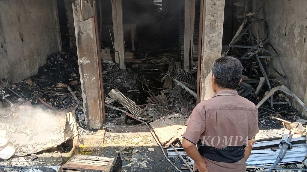 Ujang (68), pedagang pakaian, berdiri menyaksikan puing-puing sisa kebakaran di kiosnya Pasar Leuwiliang, Kamis (28/9/2023). Pasar Leuwiliang terbakar pada Rabu (27/9/2023) malam sehingga menghanguskan ribuan lapak.