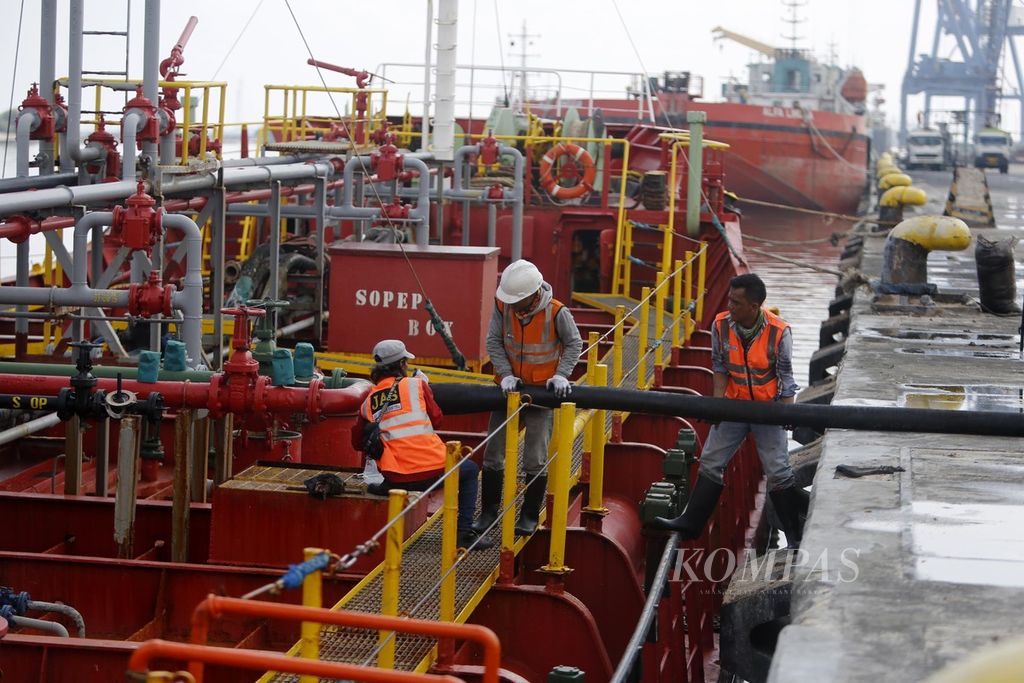 Sejumlah petugas memasang pipa untuk memindahkan minyak kelapa sawit mentah (CPO) dari Sampit, Kalimantan Tengah, ke truk tangki di Pelabuhan Tanjung Priok, Jakarta, Kamis (4/8/2022).